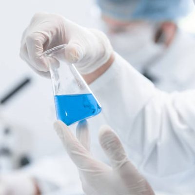 close up. a scientist looking at a liquid in a medical flask. photo with a copy-space.