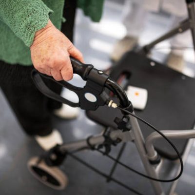 Germany: A detail of an old woman holding onto a walking frame.